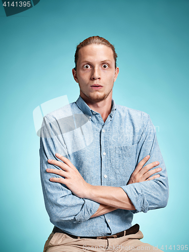 Image of The surprised young man over blue background