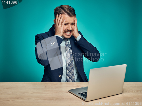 Image of Sad Young Man Working On Laptop At Desk