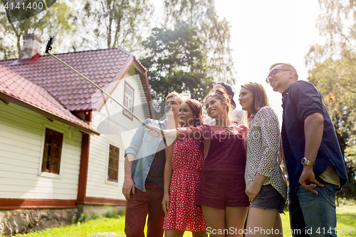 Image of friends taking selfie at party in summer garden