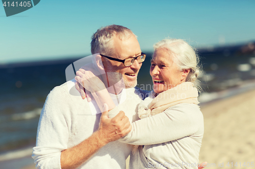 Image of happy senior couple hugging on summer beach