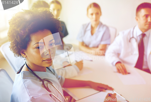 Image of female doctor over group of medics at hospital