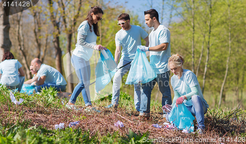 Image of volunteers with garbage bags cleaning park area