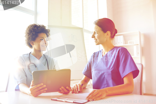 Image of happy doctors with tablet pc meeting at hospital