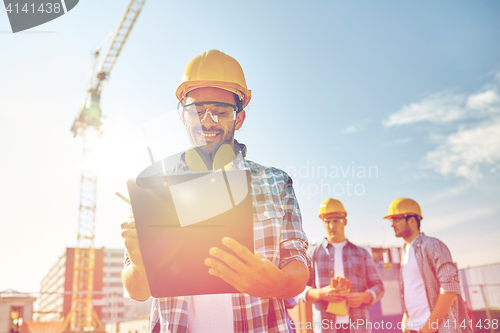 Image of builder in hardhat with clipboard at construction