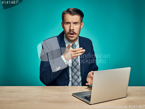 Image of Sad Young Man Working On Laptop At Desk