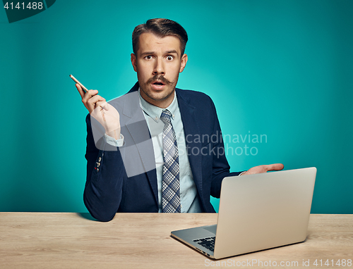 Image of Sad Young Man Working On Laptop At Desk