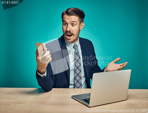 Image of Sad Young Man Working On Laptop At Desk