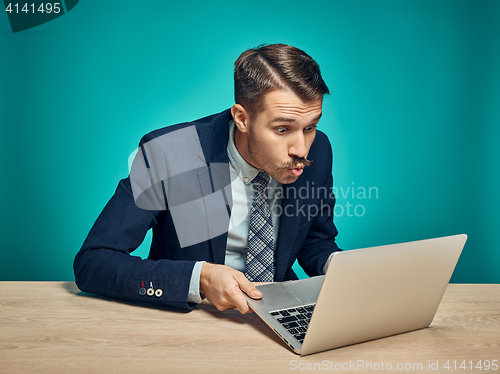 Image of Sad Young Man Working On Laptop At Desk