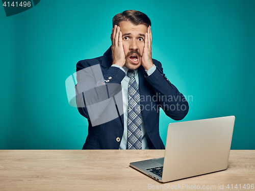 Image of Sad Young Man Working On Laptop At Desk