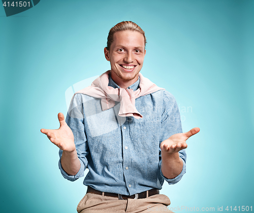 Image of Happy excite young man smiling over blue background