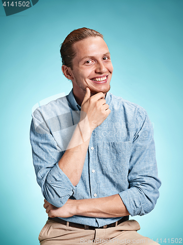 Image of Happy excite young man smiling over blue background