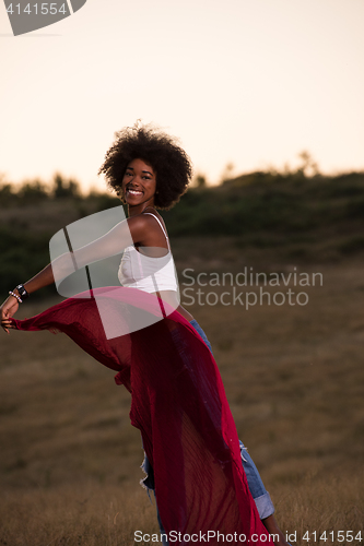 Image of black girl dances outdoors in a meadow