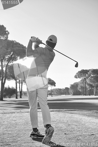 Image of golf player hitting shot with club