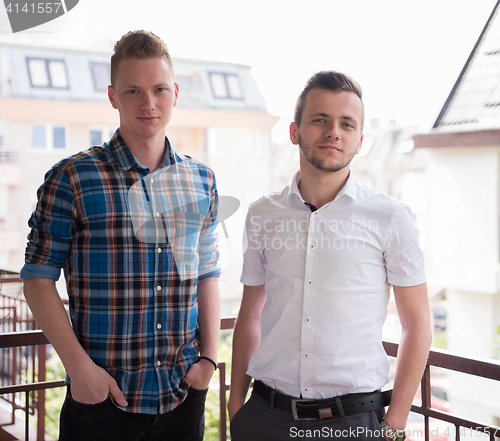 Image of two young men standing at balcony