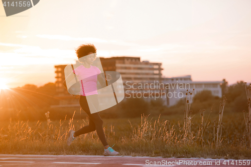 Image of a young African American woman jogging outdoors