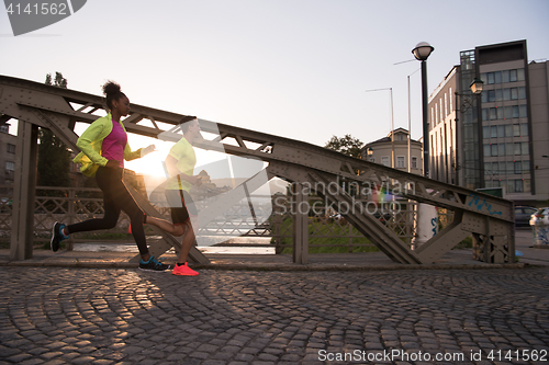 Image of young multiethnic couple jogging in the city