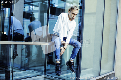 Image of young modern hipster guy at new building university blond fashion hairstyle having fun, lifestyle people concept