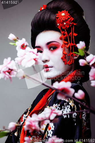 Image of young pretty geisha in kimono sakura view