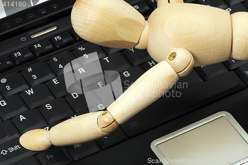 Image of wood mannequin and laptop