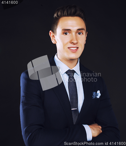 Image of young pretty business man standing on black background, modern h