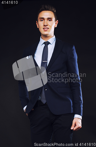 Image of young pretty business man standing on black background, modern h