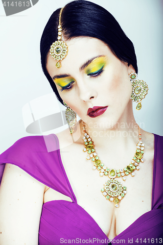 Image of young pretty caucasian woman like indian in ethnic jewelry close up on white, bridal makeup