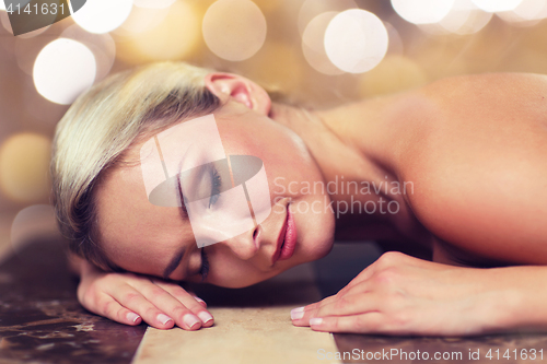 Image of young woman lying on hammam table in turkish bath