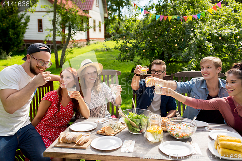 Image of happy friends having party at summer garden