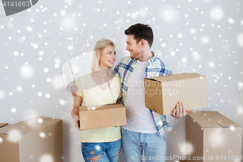 Image of smiling couple with boxes moving to new home