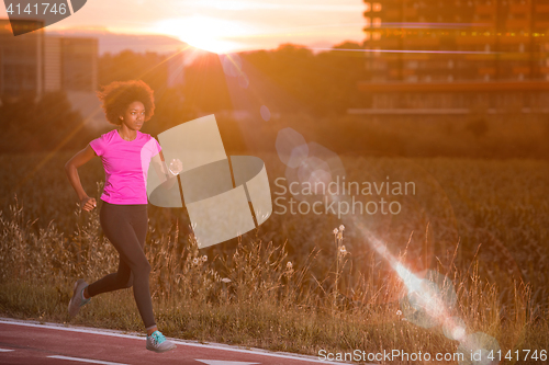 Image of a young African American woman jogging outdoors