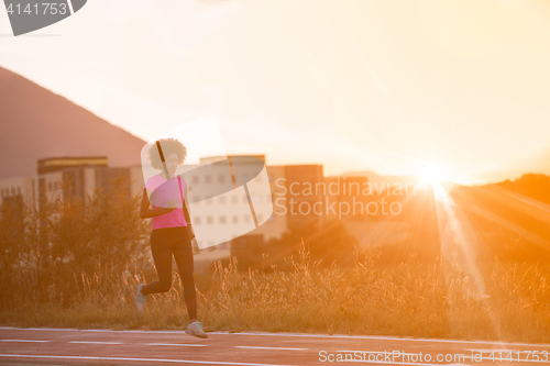 Image of a young African American woman jogging outdoors