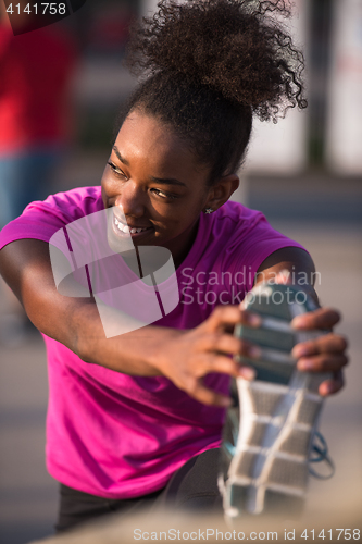 Image of African American woman doing warming up and stretching