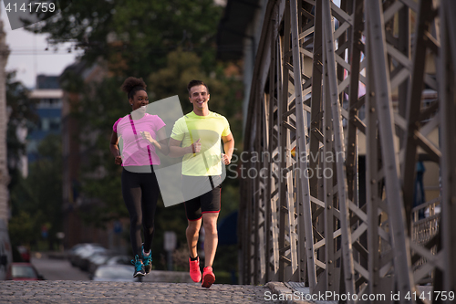 Image of multiethnic couple jogging in the city