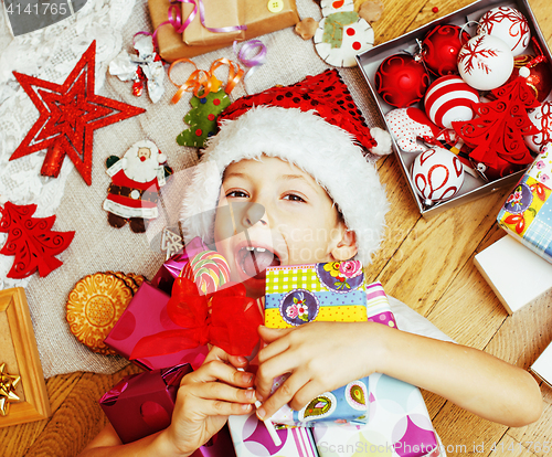 Image of little cute kid in santas red hat with handmade gifts, toys vint