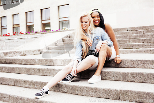 Image of Two teenage girls infront of university building smiling, having