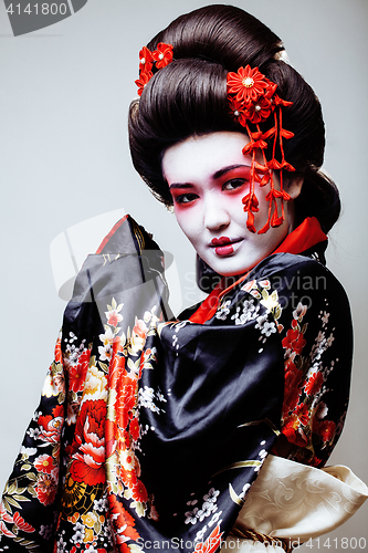 Image of young pretty geisha in kimono on white background