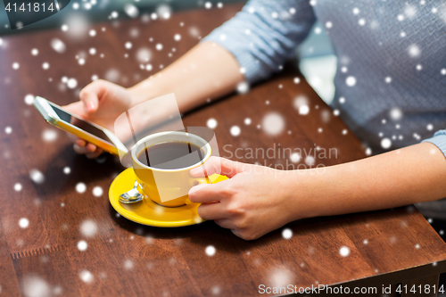 Image of woman with smartphone drinking coffee at cafe