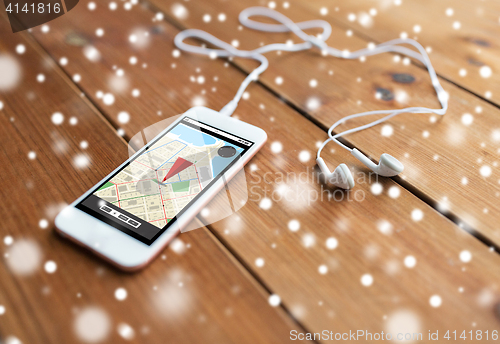 Image of close up of smartphone and earphones on wood