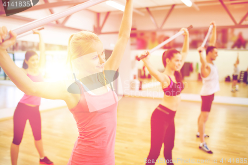 Image of group of people working out with barbells in gym