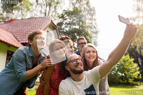 Image of friends taking selfie at party in summer garden