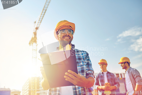 Image of builder in hardhat with clipboard at construction