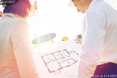 Image of close up of architects with blueprint at building