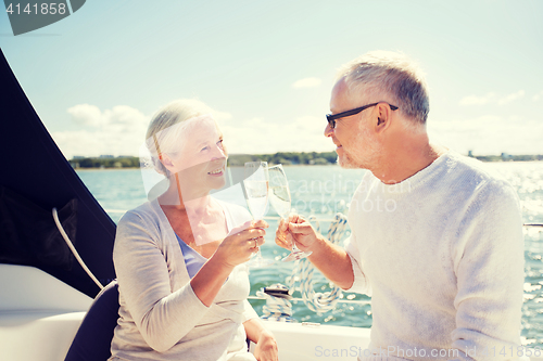 Image of senior couple clinking glasses on boat or yacht