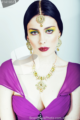 Image of young pretty caucasian woman like indian in ethnic jewelry close up on white, bridal makeup