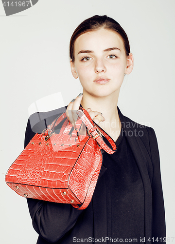 Image of young pretty cool fashion business lady wearing black suit and orange little bag smiling on white background, lifestyle people concept