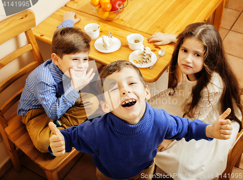 Image of little cute boys eating dessert on wooden kitchen. home interior. smiling adorable friendship together forever friends, lifestyle people concept