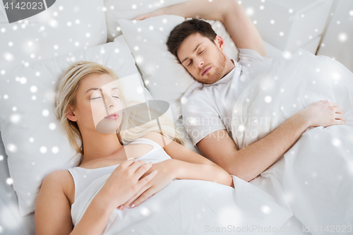 Image of happy couple sleeping in bed at home