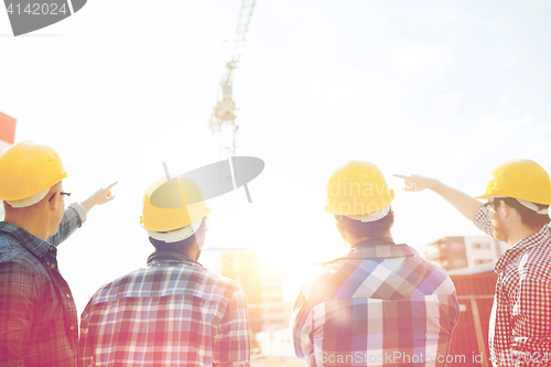 Image of group of builders in hardhats at construction site