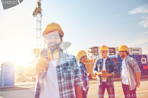 Image of builders showing thumbs up at construction site