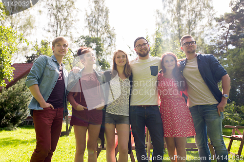 Image of happy teenage friends hugging at summer garden